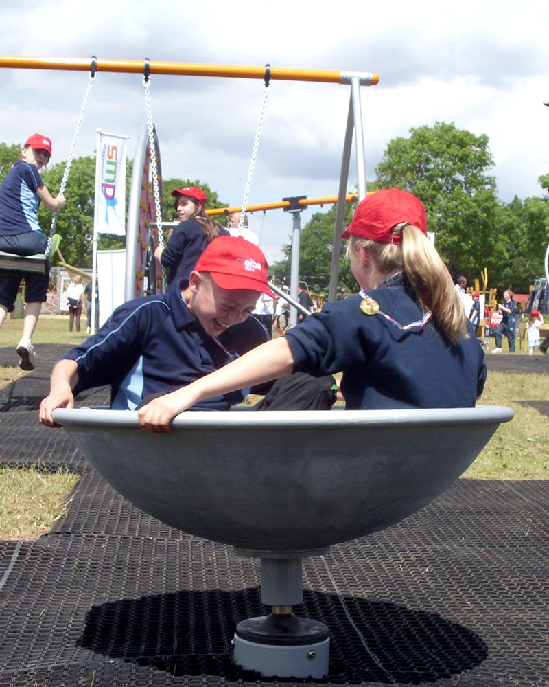 Children spin on a spinner which is egg cup shaped.